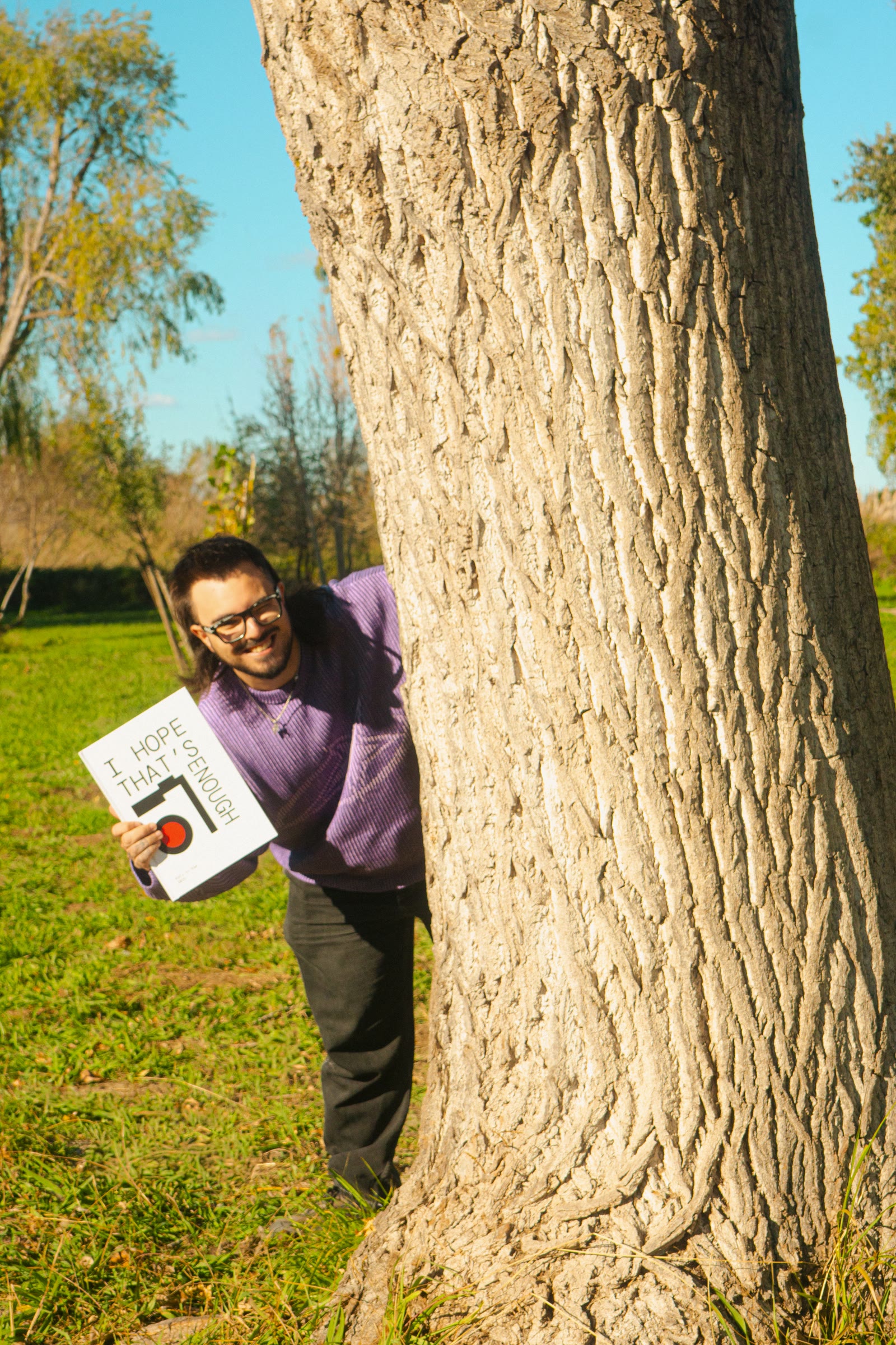Rafa asomándose tras un árbol con su fotolibro